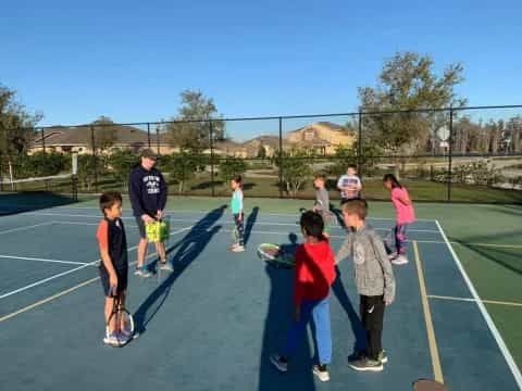 a group of kids playing tennis