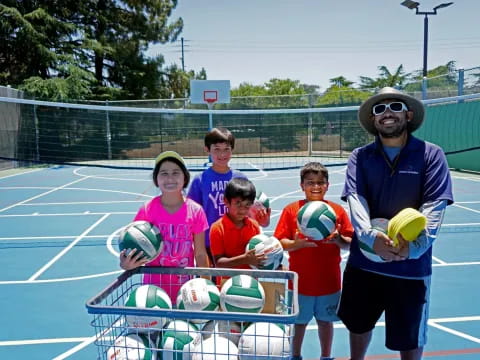 a group of kids posing for a photo with a tennis racket