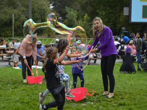 a group of people playing with a large yellow and red object