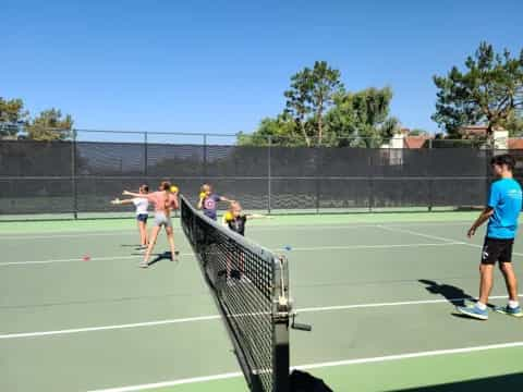 people playing tennis on a court