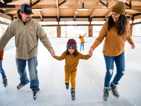 a man and woman and a child ice skating