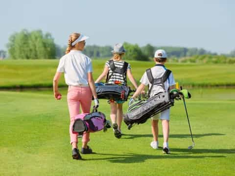 a group of people walking on a golf course