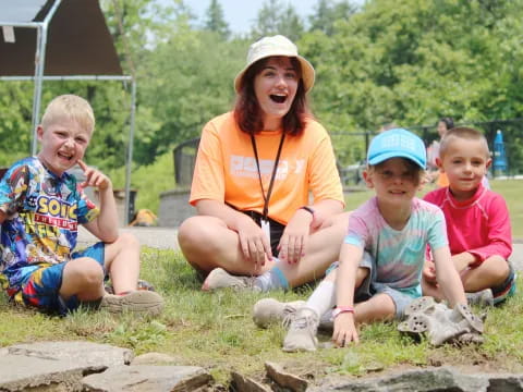 a person and several children sitting on the ground