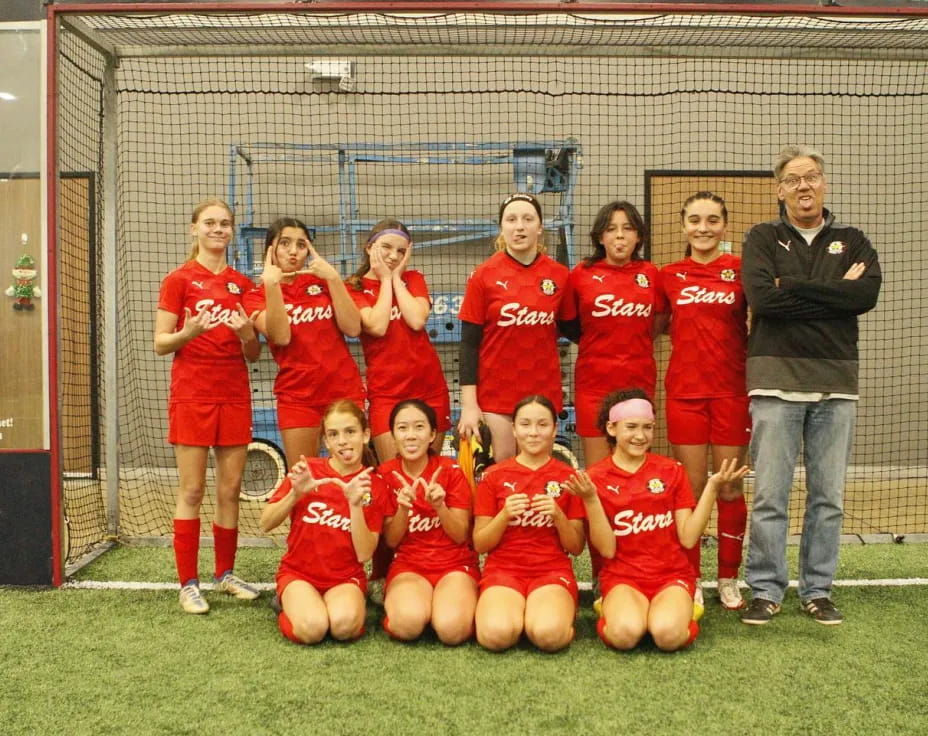 a group of people in sports uniforms posing for a photo