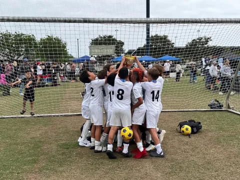 a group of people in white uniforms holding a yellow ball