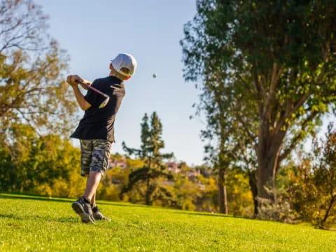 a boy swinging a golf club