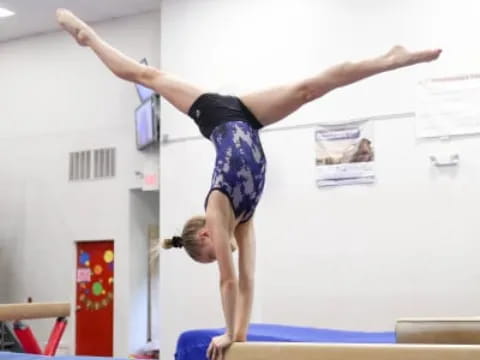 a person doing a handstand on a mat in a room