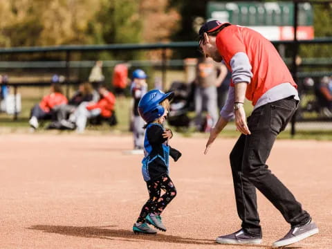 a person and a child playing baseball