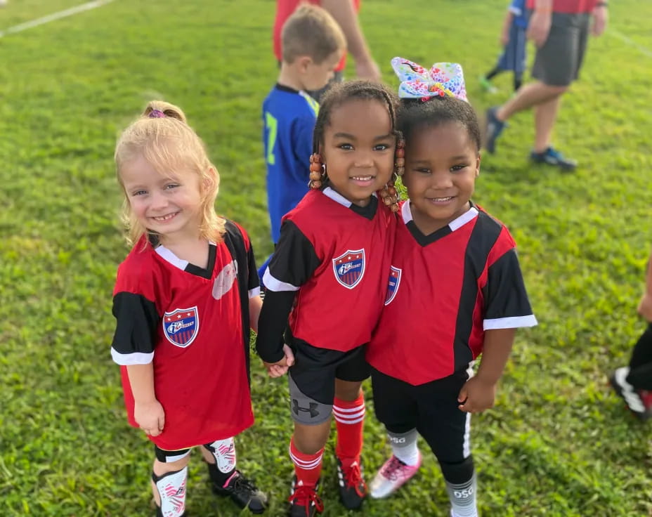 a group of children in red and blue uniforms on a field