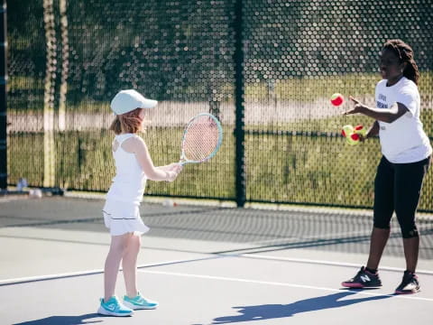 girls playing tennis on court