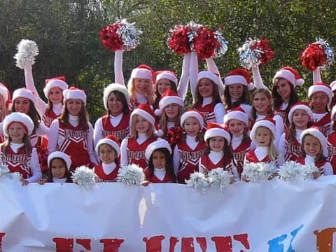 a group of people wearing santa hats and holding a sign