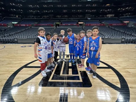 a group of boys in sports uniforms on a basketball court