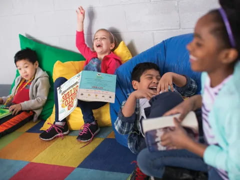 a group of children sitting on the floor and holding books