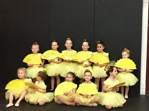 a group of children in yellow dresses