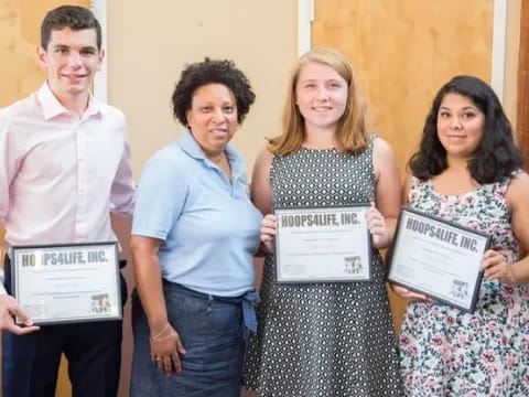 a group of people holding certificates