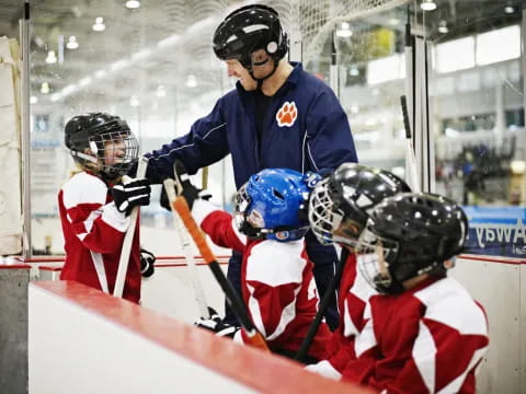 a hockey player in blue and white with a hockey stick and other players