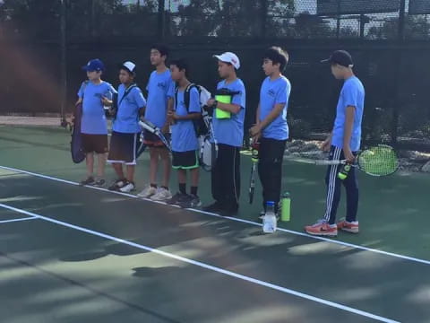 a group of people holding tennis rackets