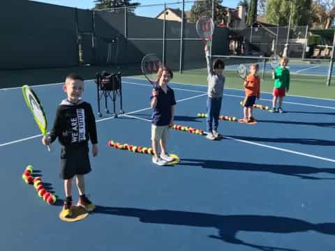 kids holding tennis rackets