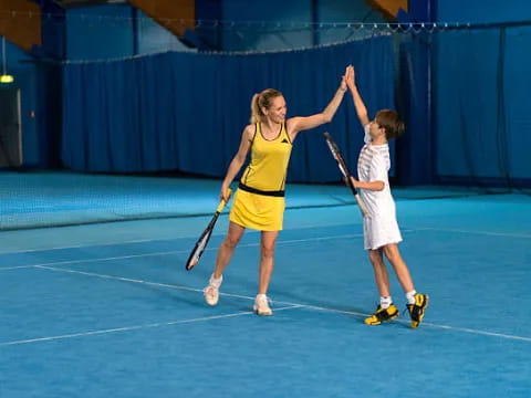a woman and a boy playing tennis