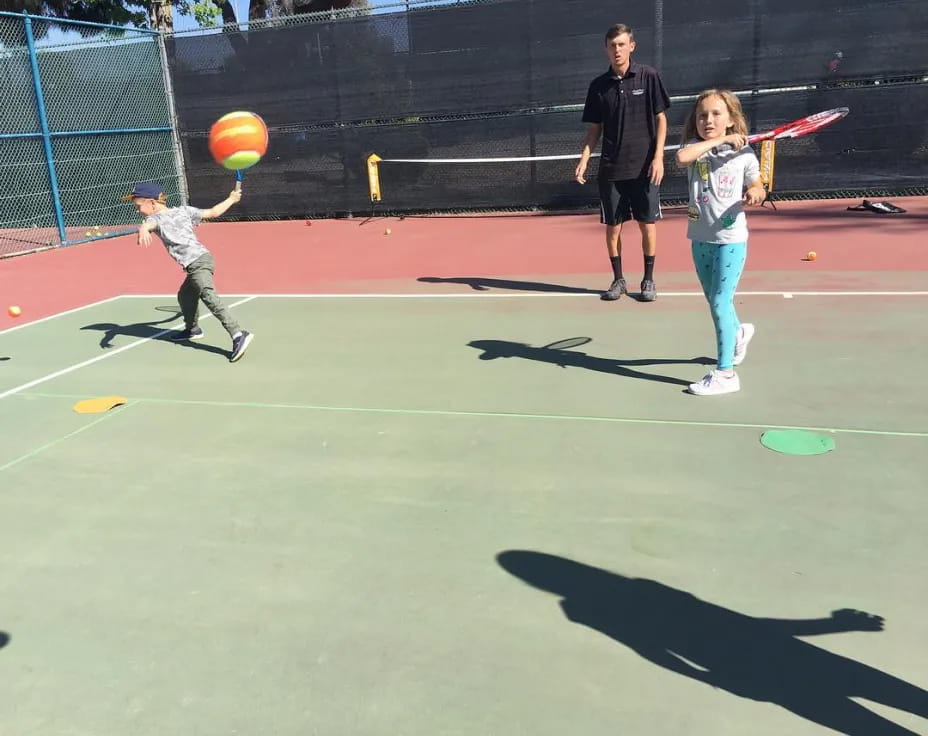 a girl hitting a ball with her bat