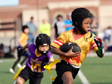 a person holding a ball and running with a kid