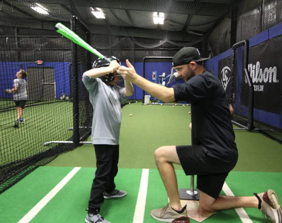 a person hitting a ball with a baseball bat