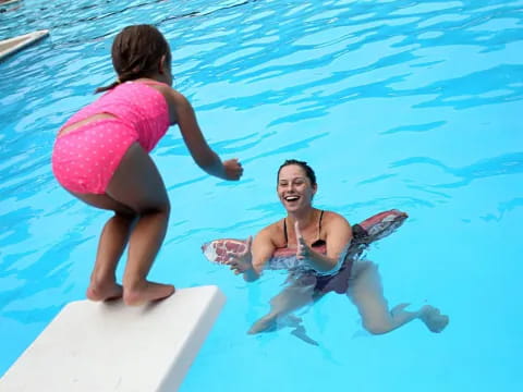 a person and a girl in a pool