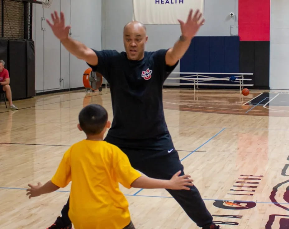 a person and a boy playing basketball