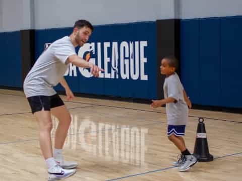 a person and a boy playing basketball