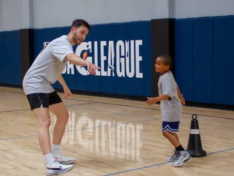 a person and a boy playing basketball