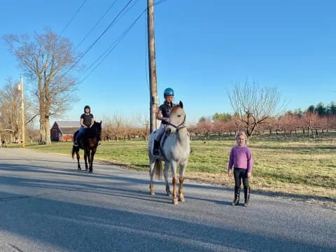 a woman walking with a man on a horse and a woman walking by