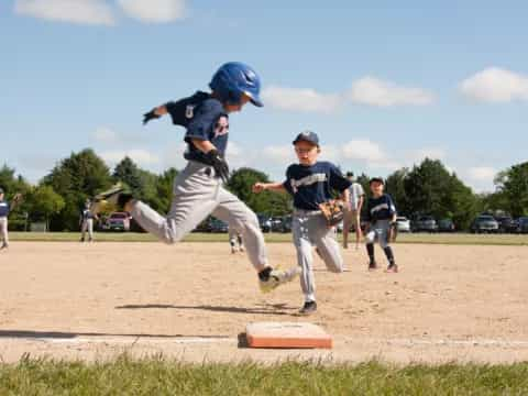 a kid jumping over a base