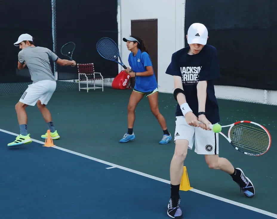 a group of people play tennis