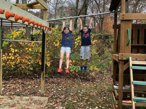 two kids standing in a play structure
