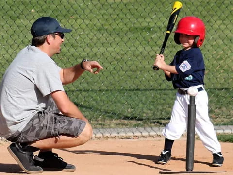 a person and a boy playing baseball