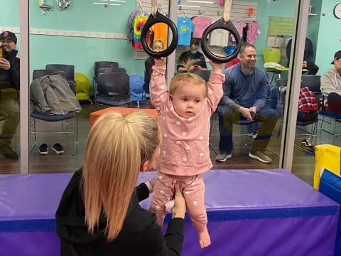 a person holding a child on a table with a racket