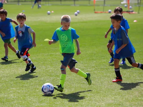 a group of kids compete over a football ball