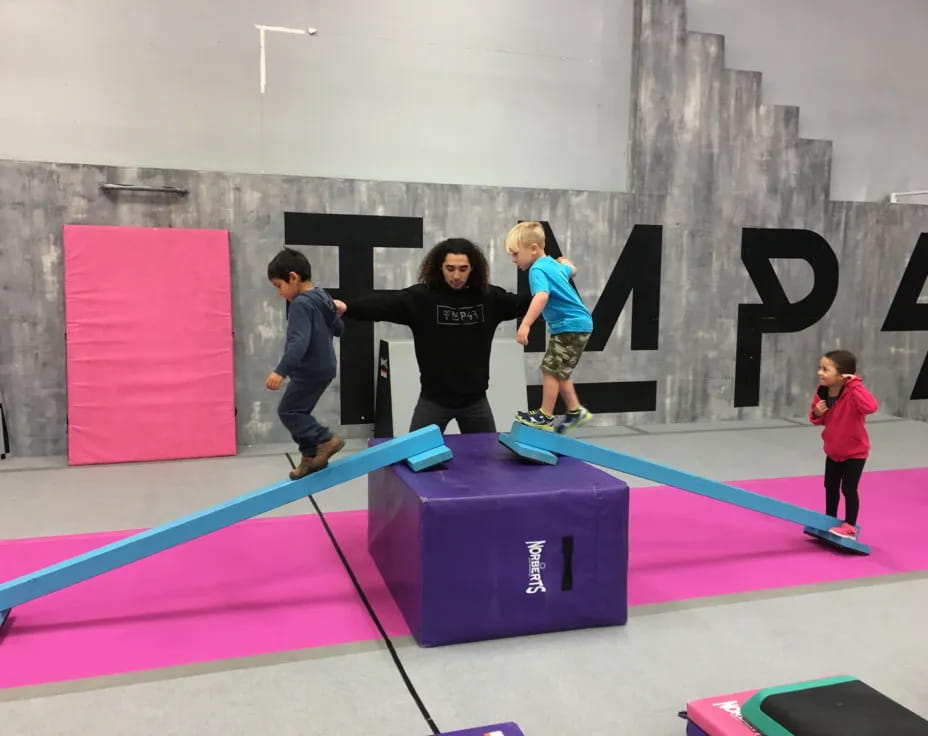 a group of kids playing on a purple mat