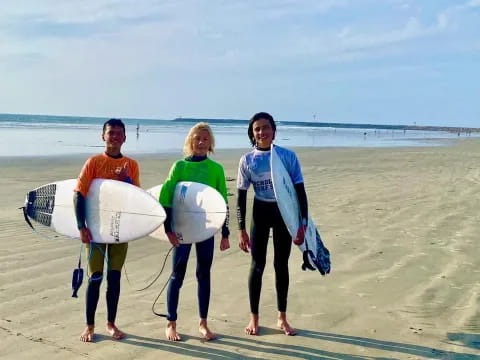 a group of people holding surfboards on a beach