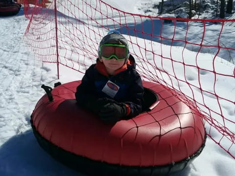 a person in a red and black tube in the snow