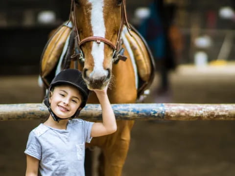 a child standing next to a horse