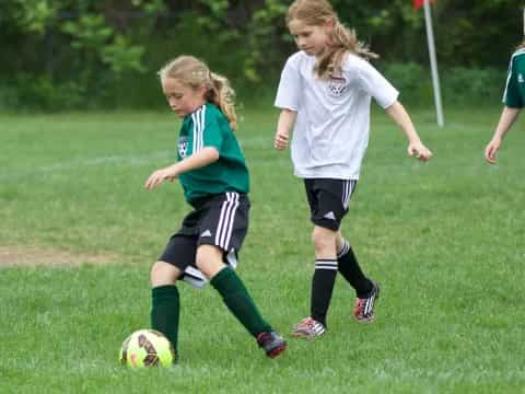 girls playing football on a field