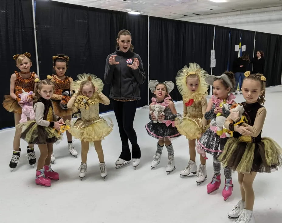 a group of people wearing ice skates posing for the camera