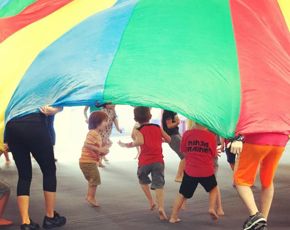 a group of people holding a rainbow colored umbrella