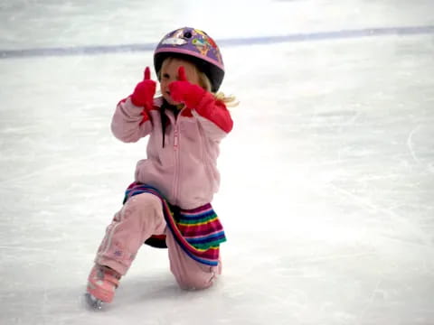 a child wearing a helmet and ice skates