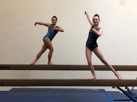 a couple of women jumping on a mat