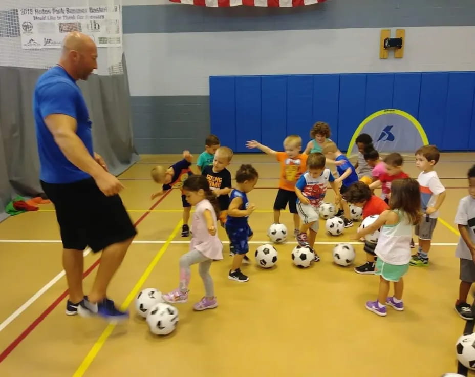 a man teaching kids how to play football