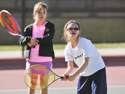 girls playing tennis on a court