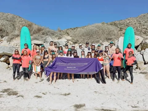 a group of people holding a purple tent on a sandy beach