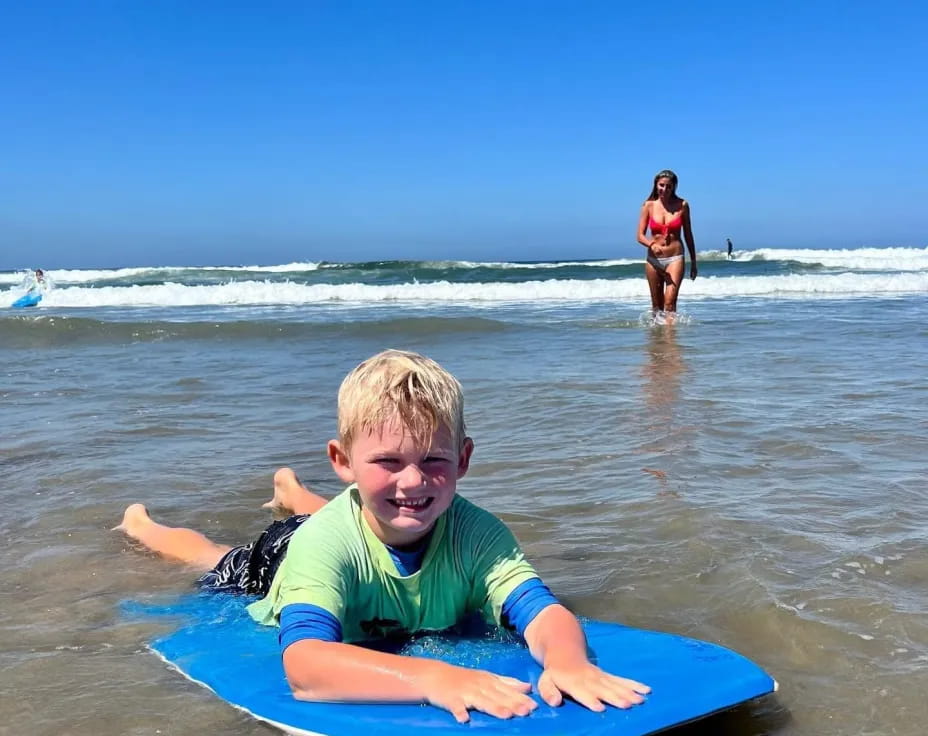 a boy on a surfboard in the ocean